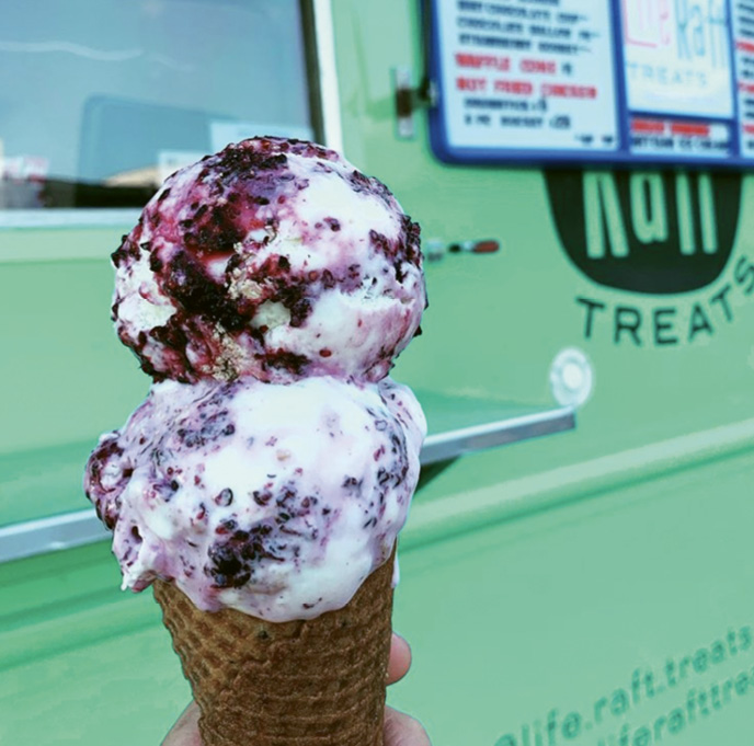 Mulberry cheesecake scoops on a brown butter waffle cone