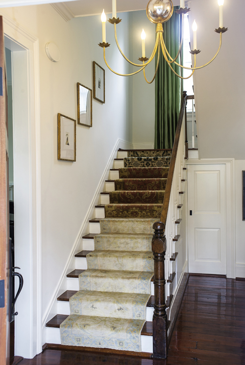 In the foyer, a runner composed of several antique and reproduction rugs sewn together strikes an eclectic welcoming note.