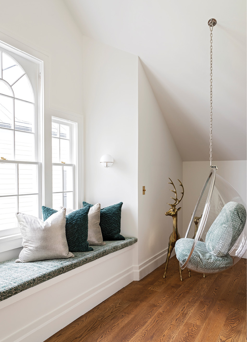 Hang Time: The top floor, a converted attic, is open and modern with a New York loft-style vibe and plenty of spots for the client’s teenage daughter and her friends to gather. A favorite is this “Bubble” chair from Modholic and window seat covered in fabric from Nobilis and pillows wrapped in material by Kirkby Design and Zinc Textile.