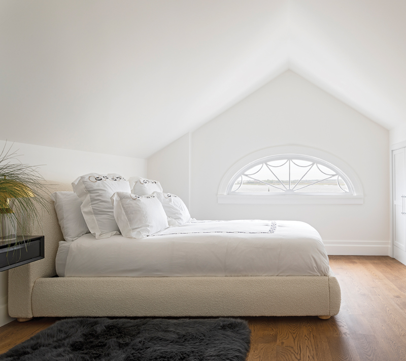 The bright and airy fourth bedroom is on the top floor, tucked behind the lunette window.