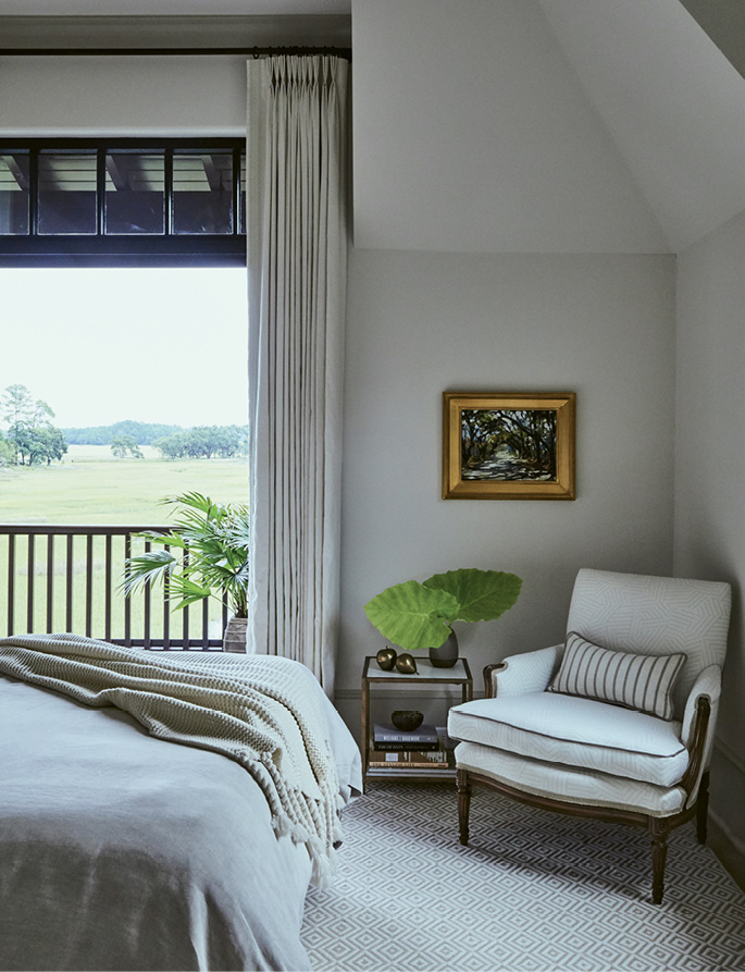 In the third bedroom, an antique chair, bought at an auction and upholstered in a Schumacher fabric, sits on a rug from Stark Carpet.