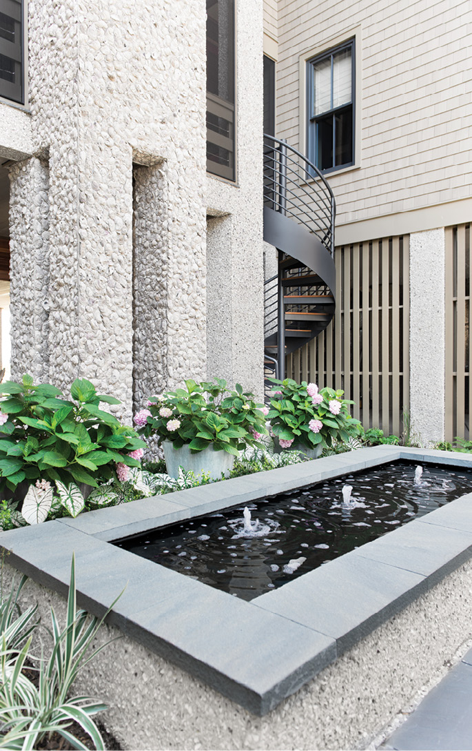 Ocean Bound: This statement-making courtyard and the spiral staircase beyond lead up to a patio featuring an oyster shell fireplace.