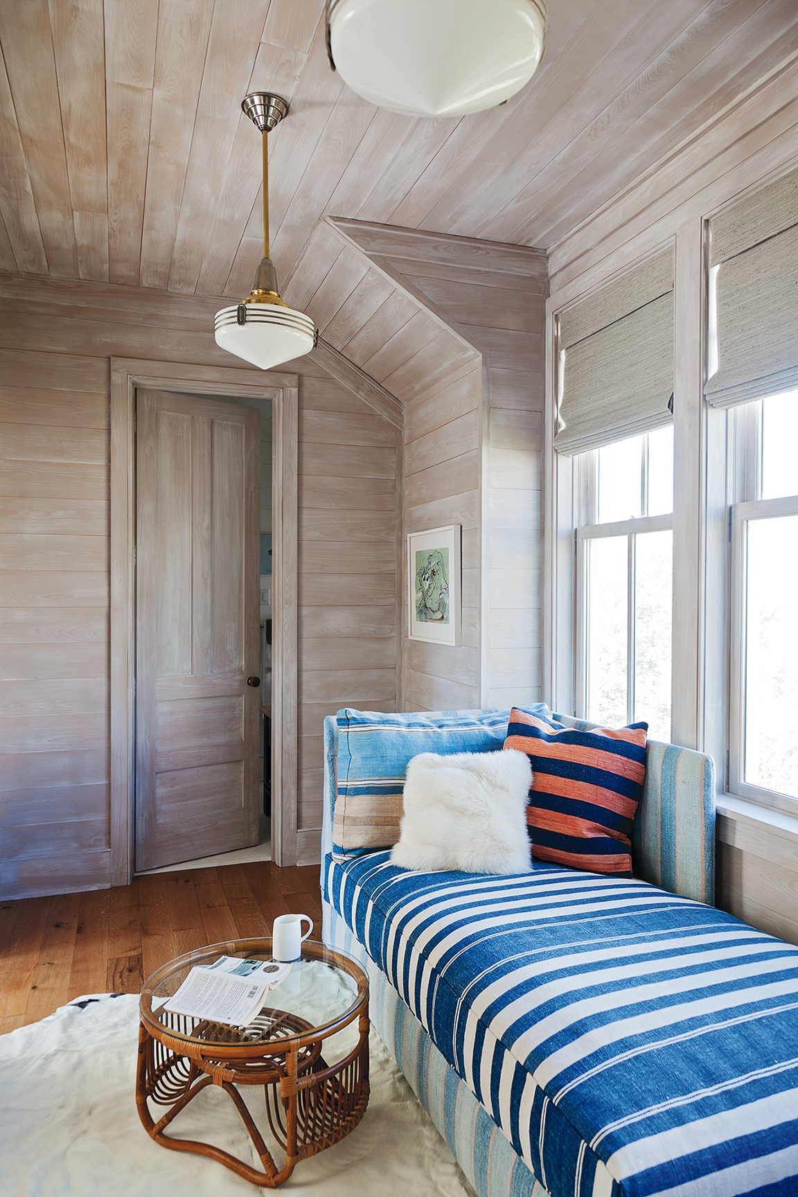 A double-duty sleeper bench upholstered in a vintage dhurrie in the cedar-lined “office”