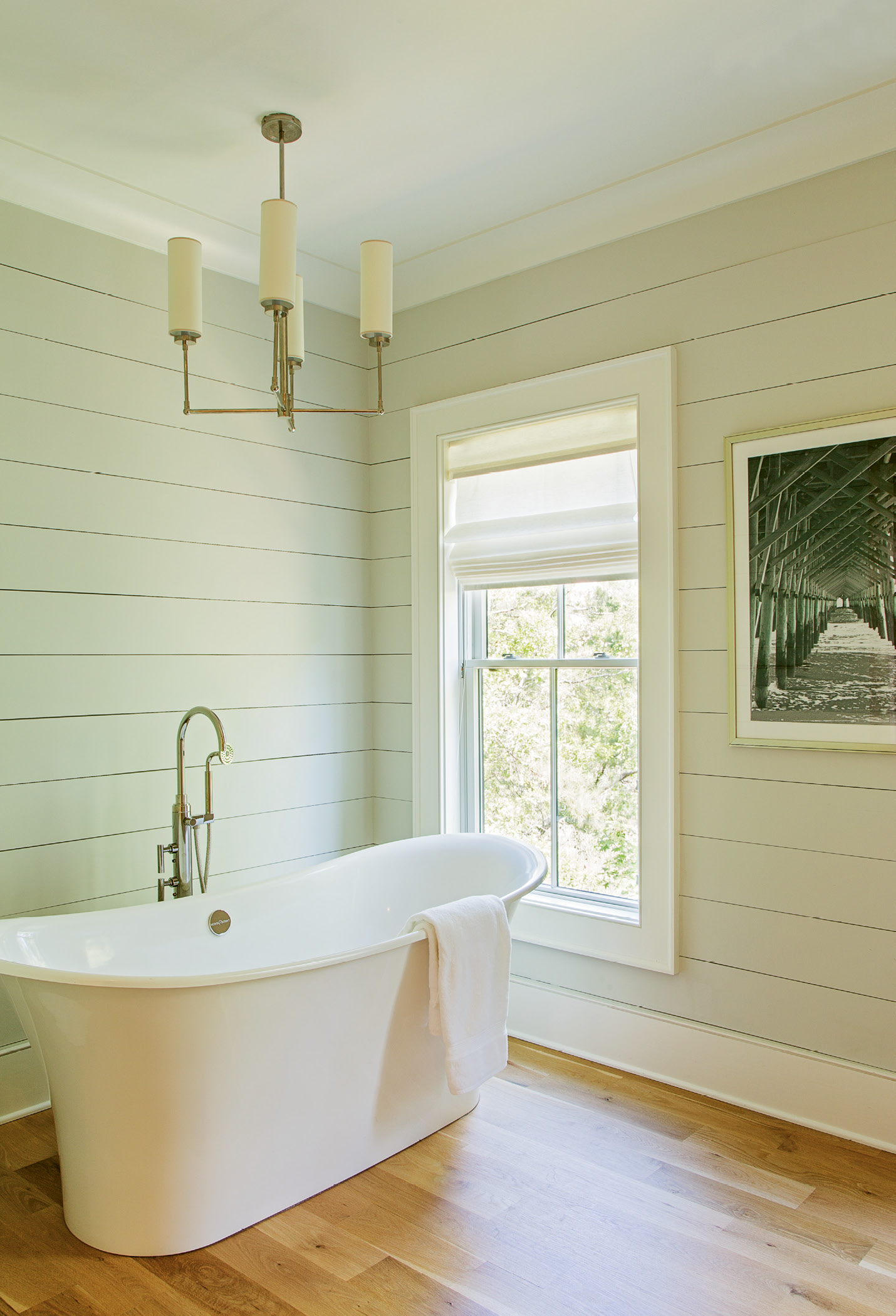 Drawing a Bath: Frank and Lenox spent days redrawing the original plans for the master bath, which entailed moving the oversized walk-in shower to another wall, and perfecting the sight lines into the bath from the hallway and again into the adjoining dressing rooms. “I love the sculptural aspect of the tub, contrasted with the angularity of the pendant light,” says Lenox.