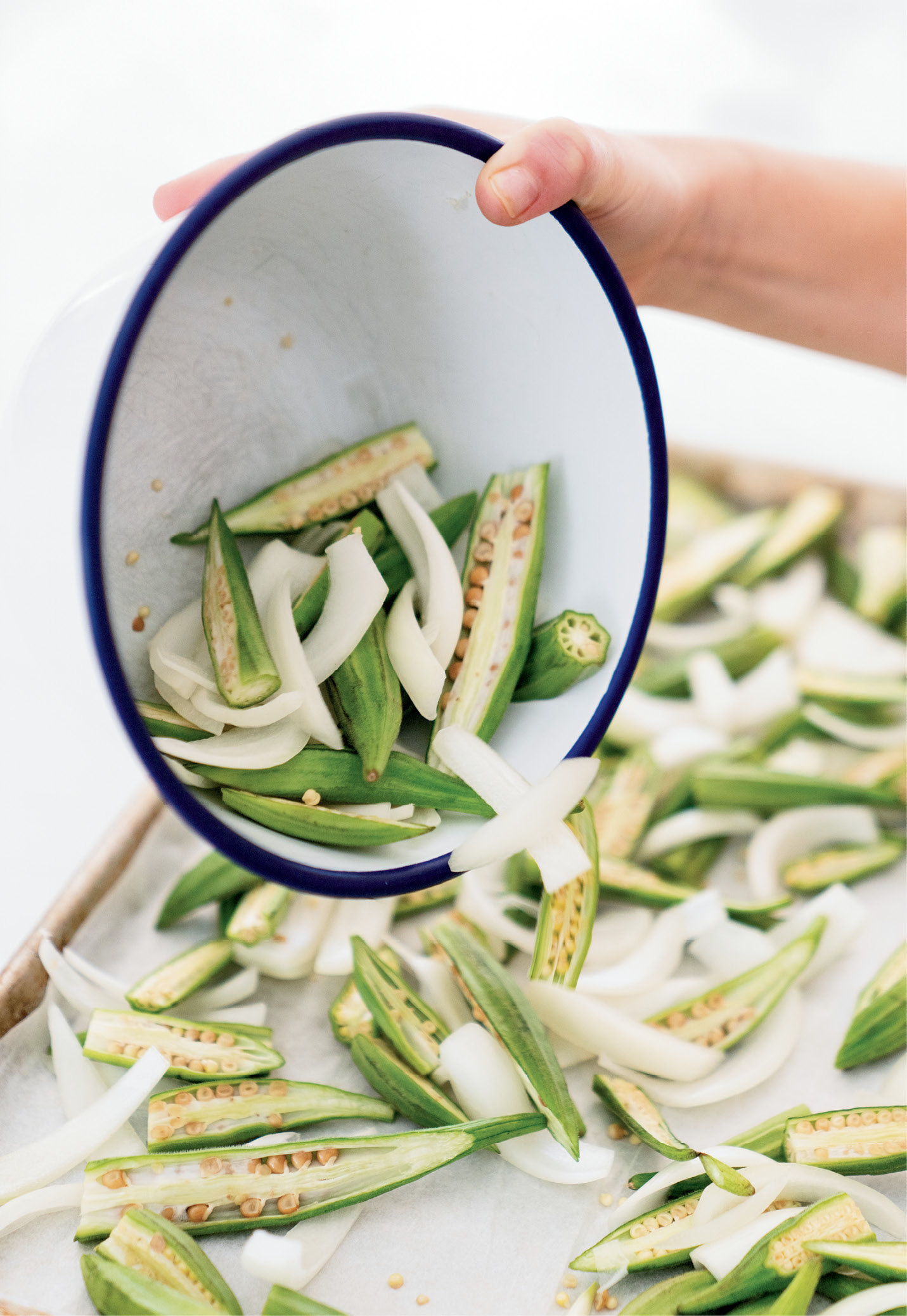 For the roasted okra, onions are added to the halved pods. After roasting in the oven, the dish is spiced up with cumin, chili powder, and cilantro.