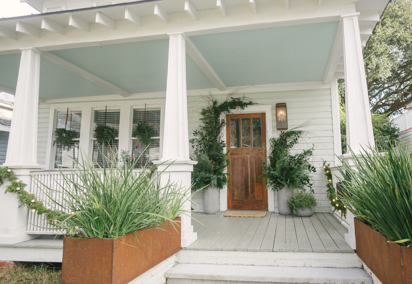 To create the installations flanking her front door, Heather starts with a frame of birch branches, anchors them in planters, then guides the branches upward.
