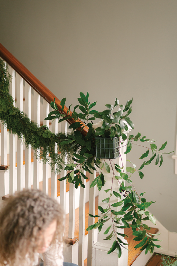 Insert your longest greens in the back. Place a few long branches facing up toward the railing and a few at the bottom to trail down.