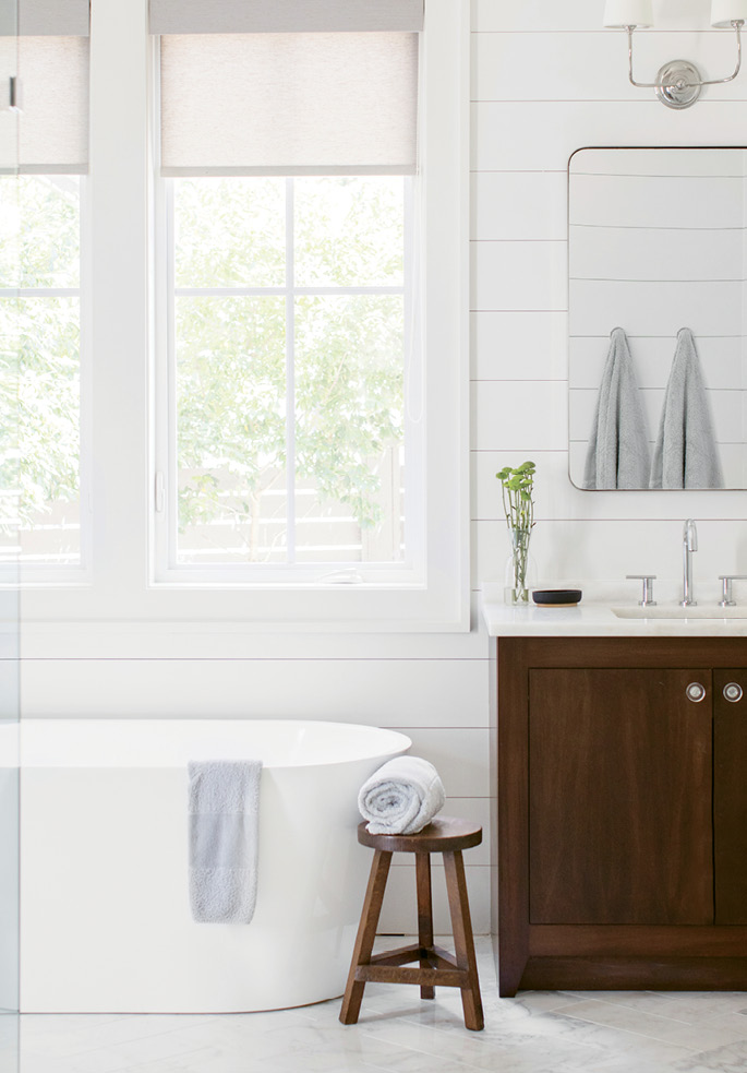R&amp;R: In the master bath, a large soaking tub overlooking the backyard separates his-and-her marble-topped vanities. An expansive shower with frameless glass and penny marble tile completes the retreat.