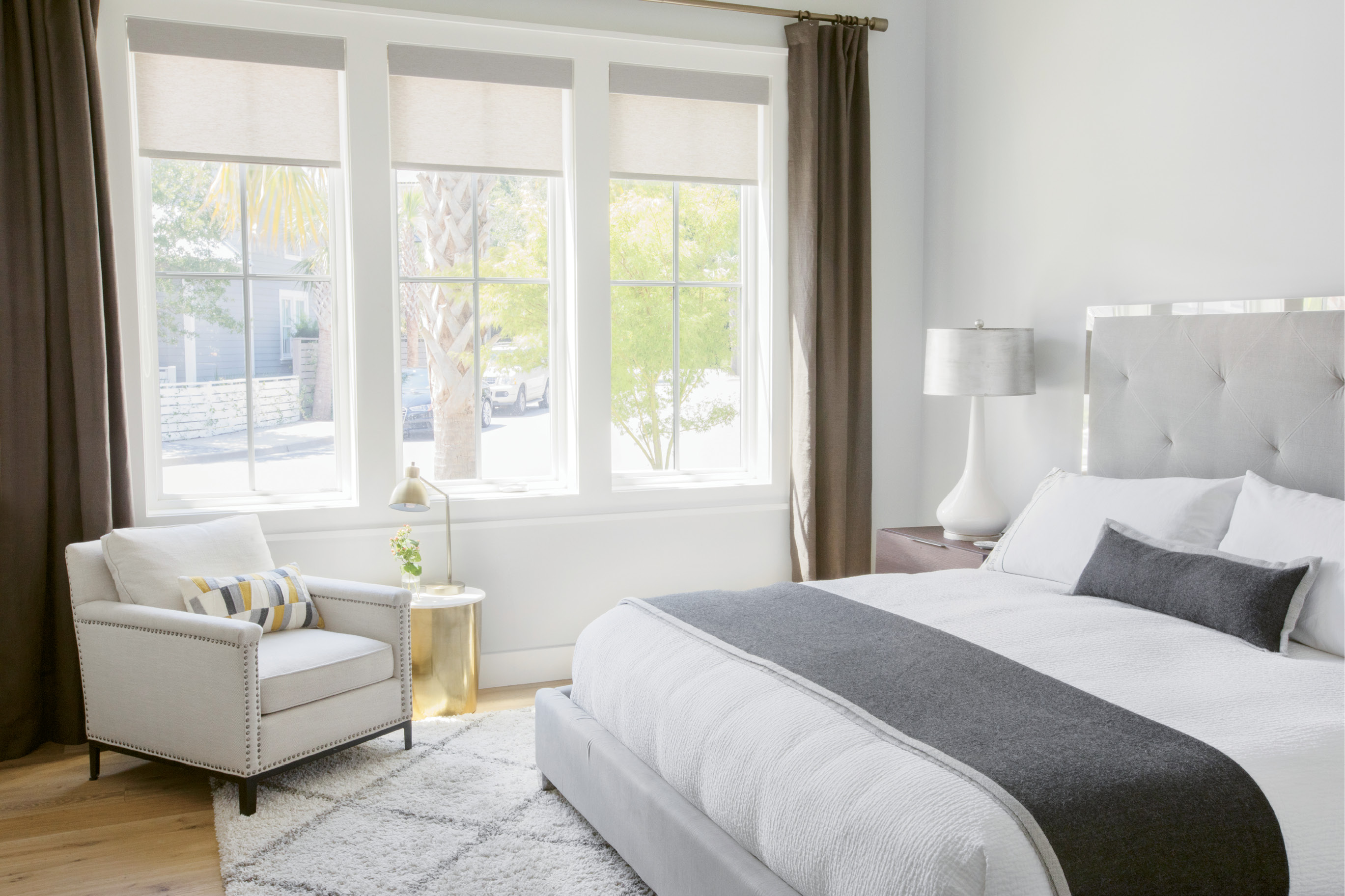 Serene Wing: Spare, modern lines continue in the first-floor master “wing” complete with 10-foot vaulted ceilings, his-and-her walk-in closets, and a laundry room hidden behind the reclaimed wood sliding door. Furnishings are a blend of older favorites with new pieces, such as the low-slung upholstered linen bed from AllModern.