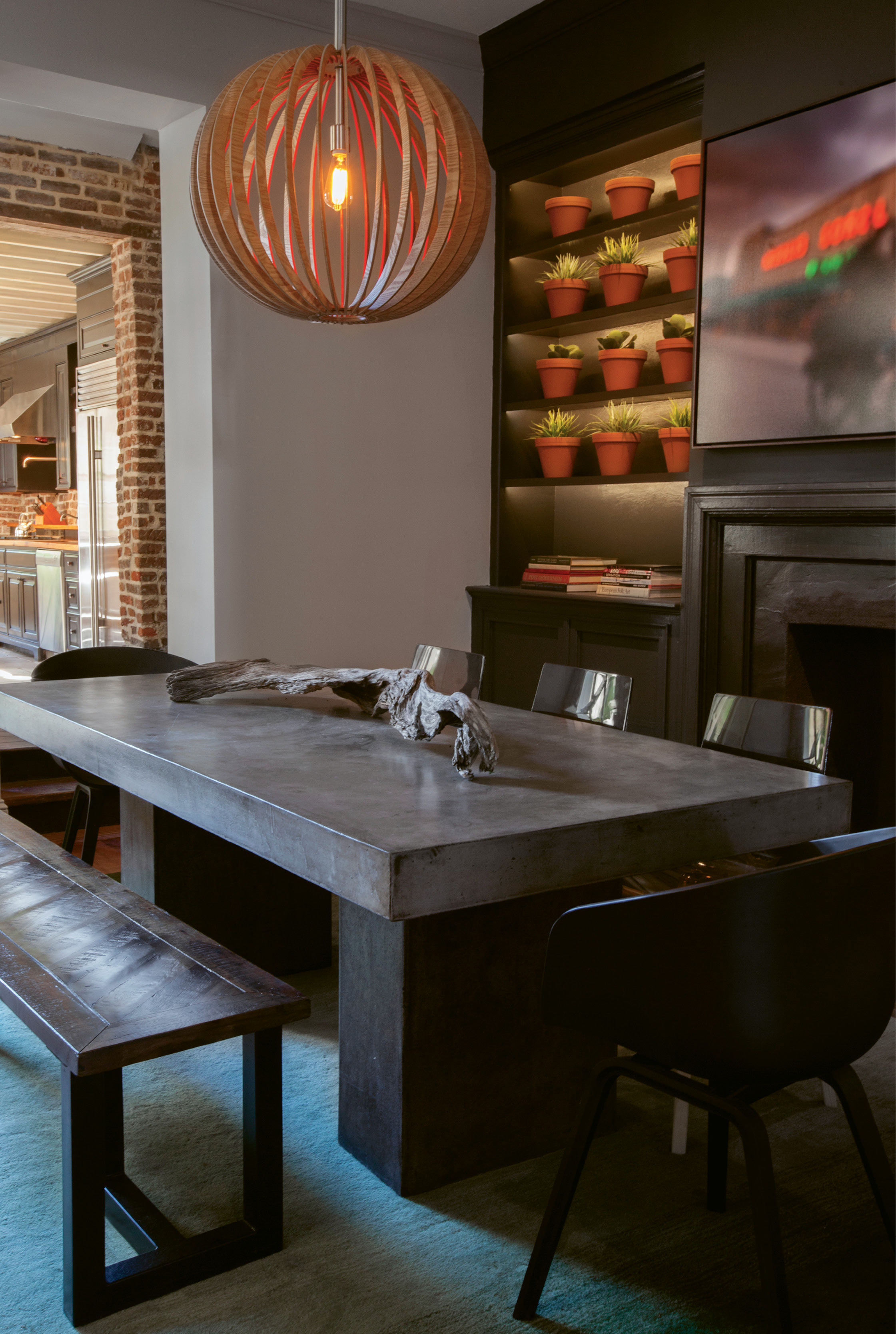 Paint It Black: In the dining room, Naylor had the idea to transform the fireplace surround and adjacent built-ins with a few coats of black paint. A wall of succulents in terra-cotta pots and a John Duckworth photograph of the old Morris Sokol building pop against the moody backdrop.