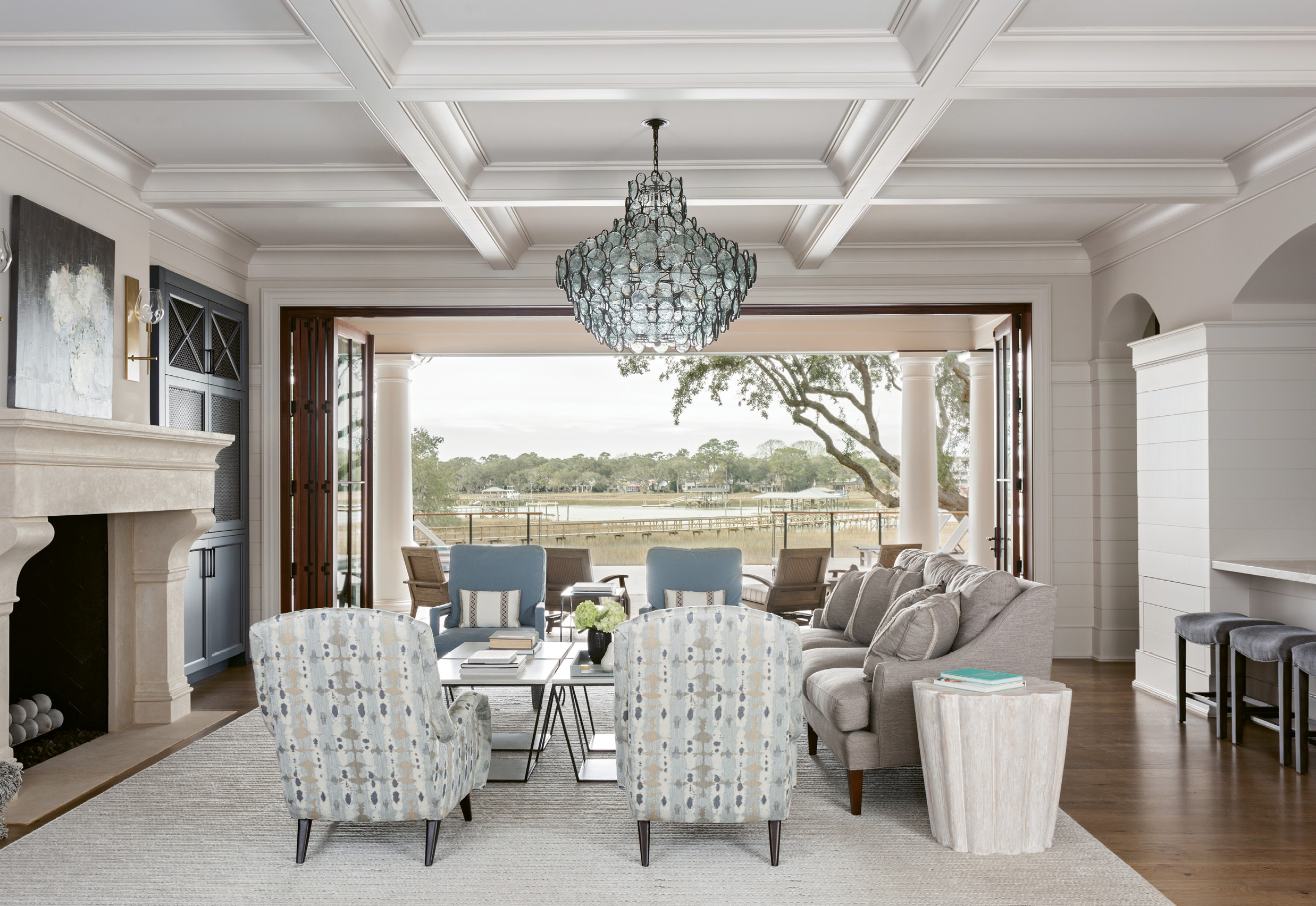 CREEKSIDE CHARMS: A wall of windows opens to bring the home’s indoor and outdoor living spaces together, offering expansive views of Wappoo Creek from the front of the home to the back.