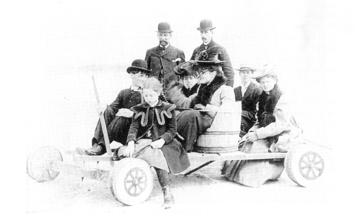 Guests visiting the Sheltering Arms orphanage ride the children’s pull cart on the beach.