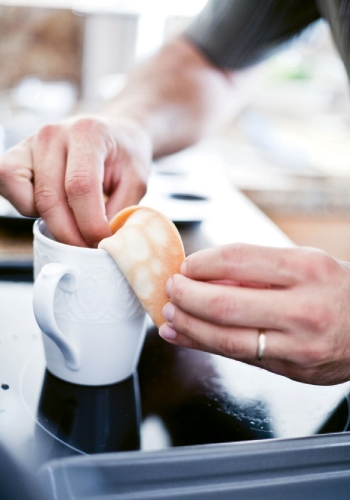 2. After baking, flip hot cookies over and place fortunes in center. Fold in half and bend edge over rim of a coffee mug. Cool for a few seconds.