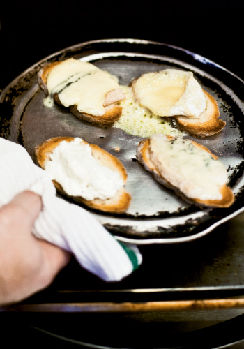 For the salad course, Perig toasts the cheese baguettes before adding truffle oil and freshly ground black pepper to the goat cheese to elevate its taste.