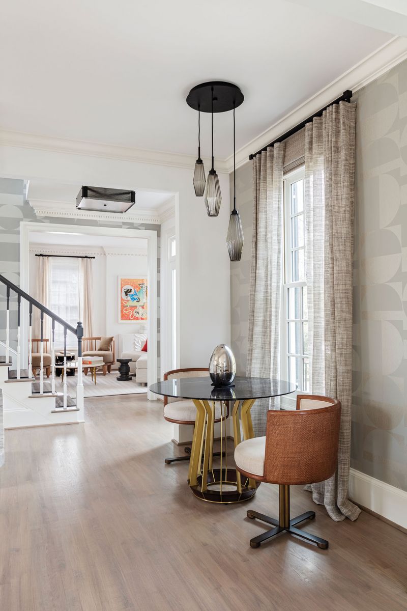 A Hellman Chang table is flanked by swivel chairs from Baker Furniture.