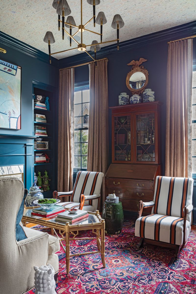 A Jonathan Adler chandelier and Thibaut “Clear Clouds” wallpaper on the ceiling lend a modern touch to a formal living room appointed with family antiques. The chairs, from John’s grandparents, are covered in a striped pattern from Thibaut.