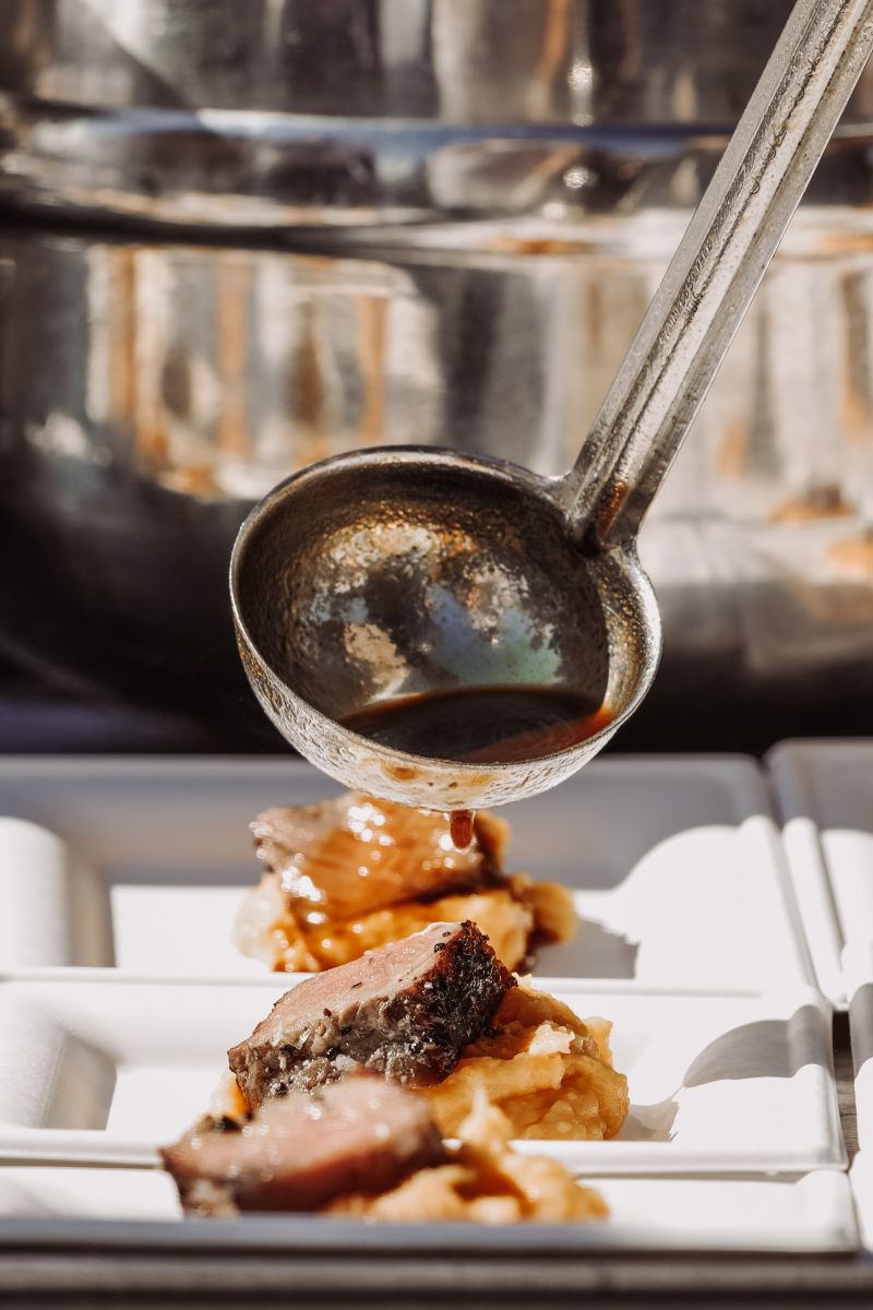 Beef jus is ladled onto a reverse-seared New York strip in the New School Village.