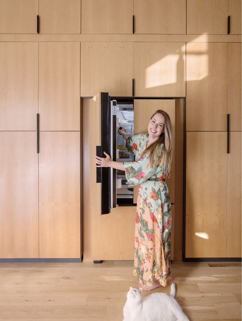 The pantry wall sits opposite the kitchen and is an ingenious space saver, concealing the fridge and providing all the storage she needs behind quartersawn white oak veneer.