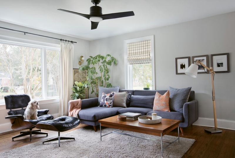 FAMILY HEIRLOOMS: In the living room, a mid-century vibe reigns thanks to a Herman Miller coffee table and Eames chair, both hand-me-downs from Jacques’s father. The umbrella plant behind the couch is also a family keepsake: after nurturing it for more than 40 years, Carrie’s father passed it down to her for safekeeping.