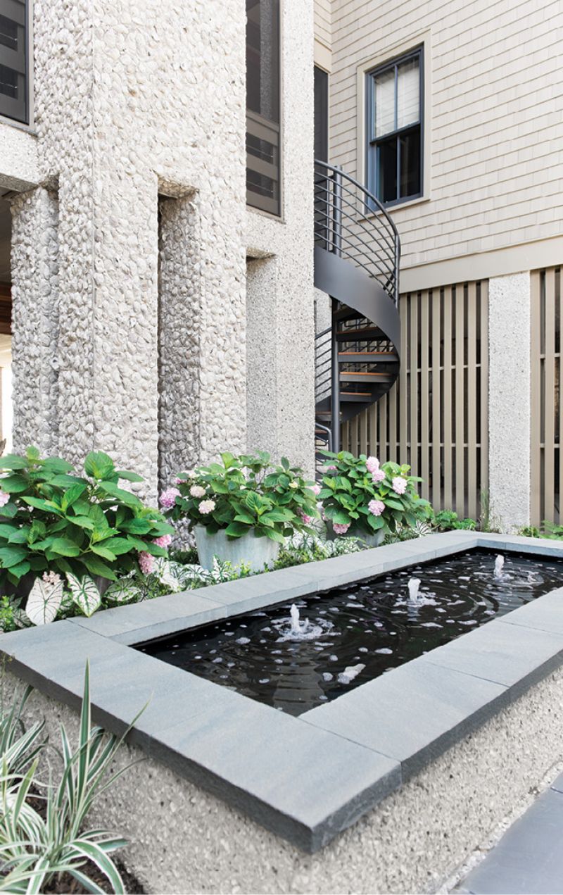 Ocean Bound: This statement-making courtyard and the spiral staircase beyond lead up to a patio featuring an oyster shell fireplace.