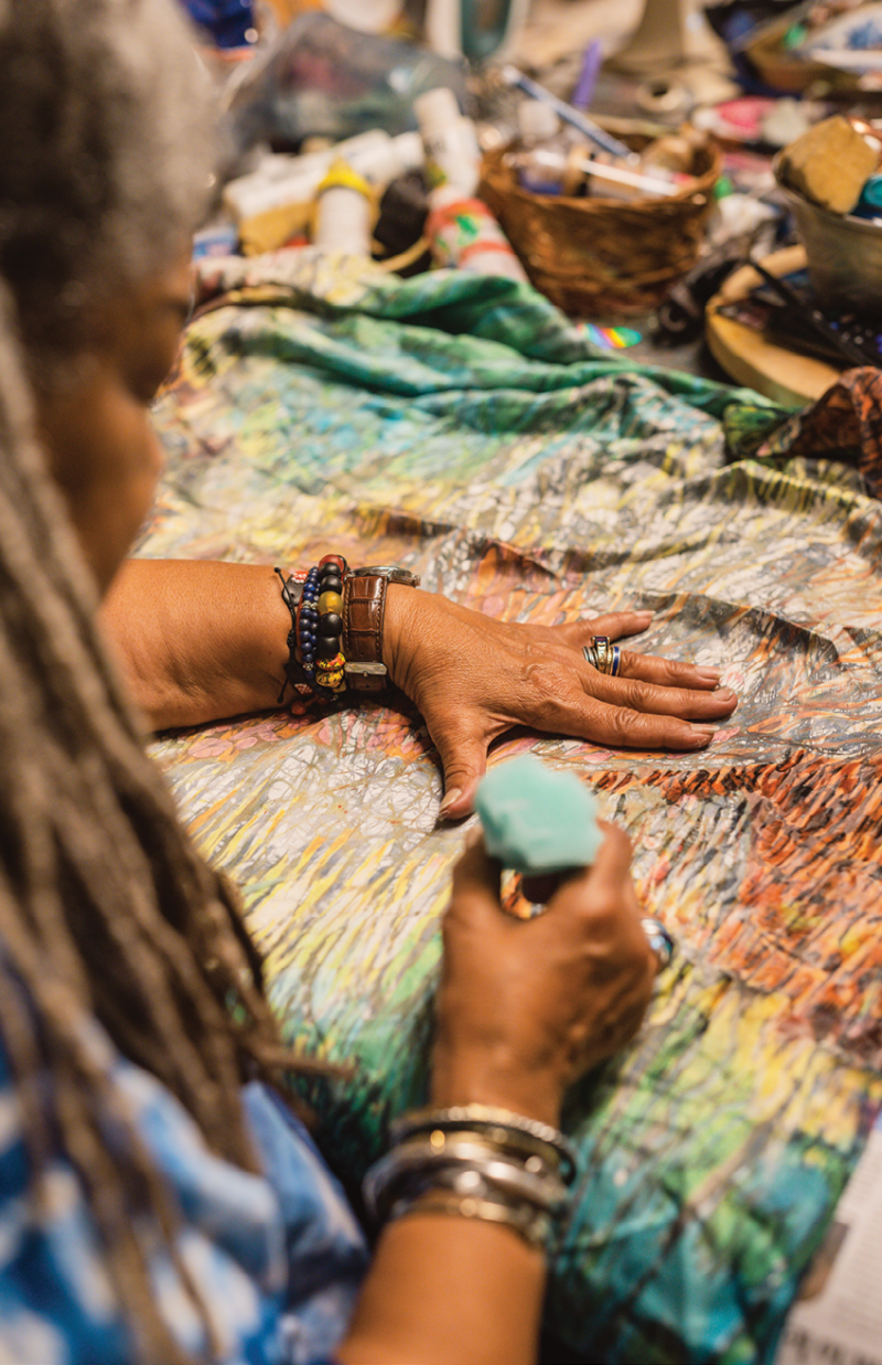 For her batik work, she uses foam rubber shaved into a cone to apply warm wax to fabric. It’s a technique she picked up while studying in Nigeria.