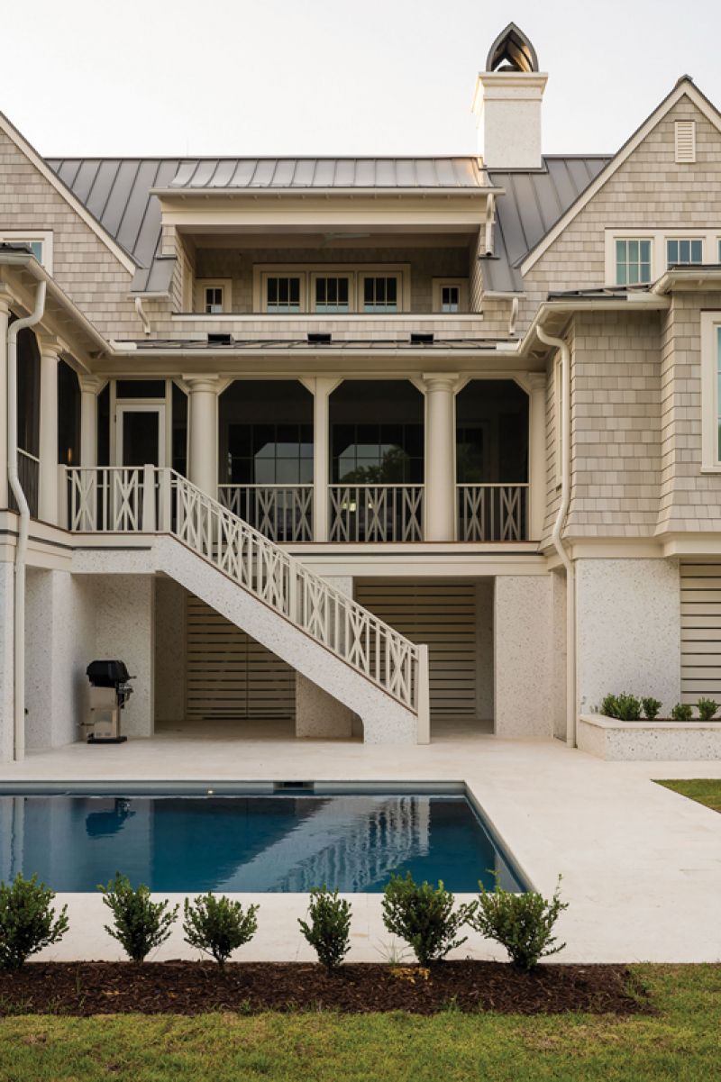 Blending in: The soft exterior palette was designed to mesh with the surrounding coastal landscape. From the light-colored NuCedar shingles and the tabby stucco to the Marvin clad windows in “Coconut Cream,” the overall look is subtle and sophisticated.