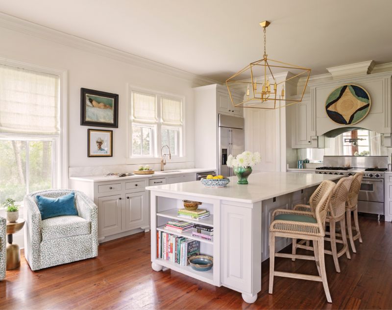 Open Up: In the kitchen, they removed built-in cabinets above the countertops and relocated them to a little-used mudroom off the kitchen, turning it in to a butler’s pantry to wrangle small appliances. New honed marble countertops, Hickory Furniture bar stools upholstered in Brunschwig &amp; Fils “La Panthere” velvet, and a striking chandelier from Lyndon Leigh spruce up the well-loved room.