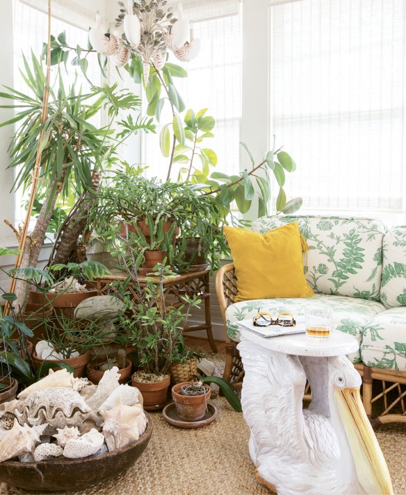 Sunshine State of Mind: A vintage terra-cotta pelican table figures prominently in the “Florida room.” Debbie scored the piece at an estate sale in Vero Beach, where she frequently goes on buying trips. The shell chandelier was found at Wynsum Antiques &amp; Interiors on King Street