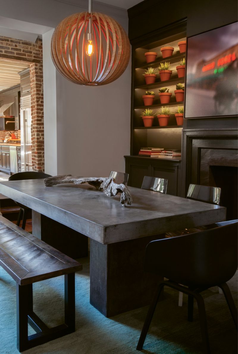 Paint It Black: In the dining room, Naylor had the idea to transform the fireplace surround and adjacent built-ins with a few coats of black paint. A wall of succulents in terra-cotta pots and a John Duckworth photograph of the old Morris Sokol building pop against the moody backdrop.