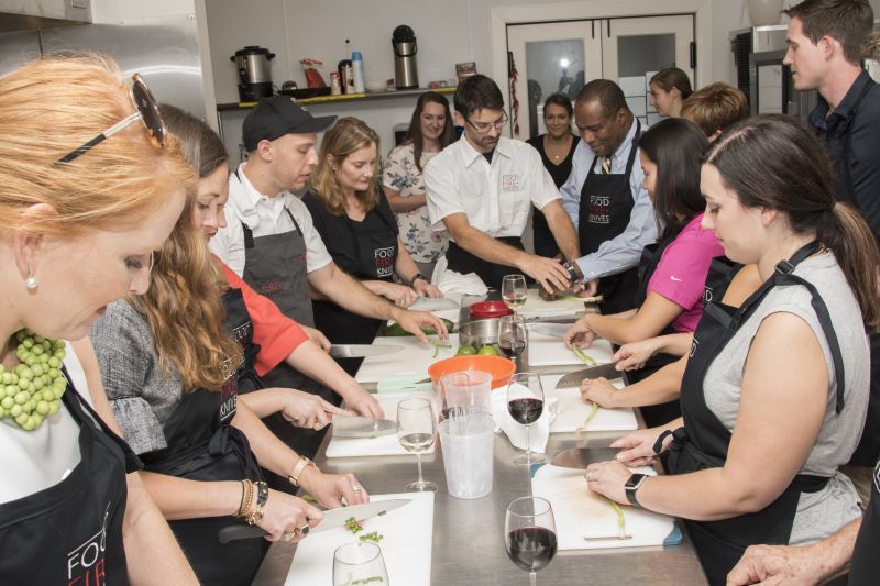 Chef Alessandro Pepe helps the class chop the scallions.