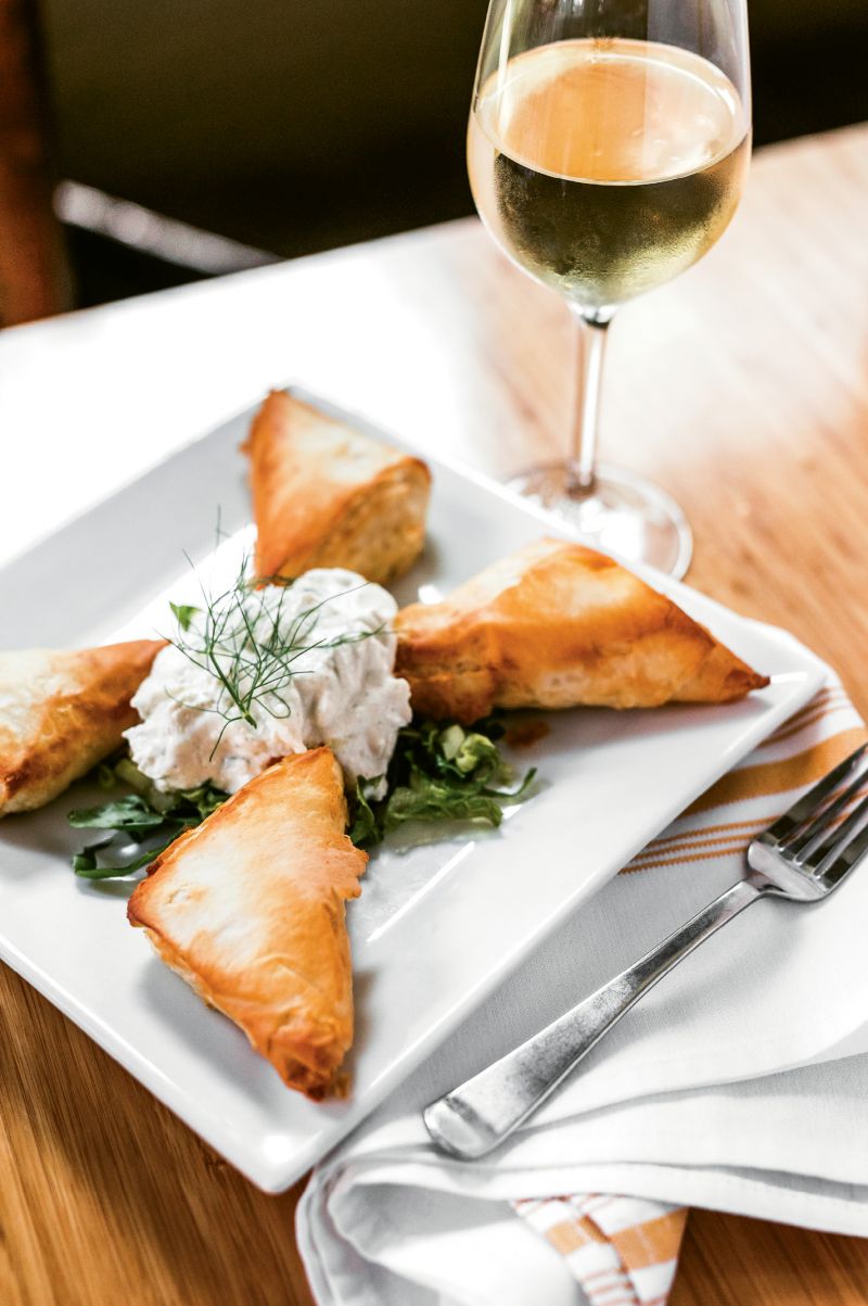 “The Stella Way”: Spanakopita, a flaky phyllo pastry filled with spinach and feta and served with tart tzatziki, is one of the traditional recipes Stella Dikos carried over from her childhood in Greece. At the restaurant, Dikos helps train the kitchen staff to cook in authentic Greek fashion, as she learned herself.