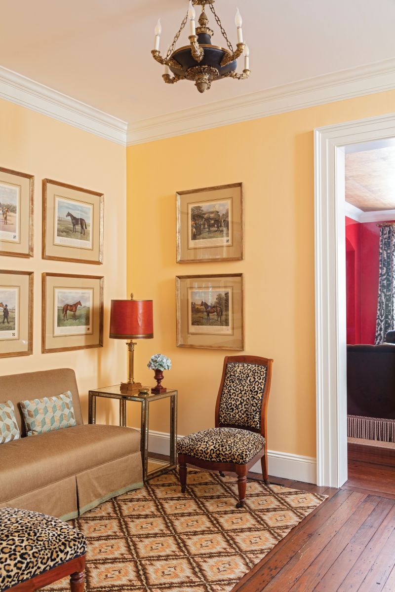 Form &amp; Function: Killian picked Benjamin Moore’s “Pineapple Orange” for the three landings along the dramatic central staircase as it complements the many colors throughout the home while holding its own. Antique slipper chairs, English horse prints, and a vintage needlepoint Stark carpet give the space a useful identity.