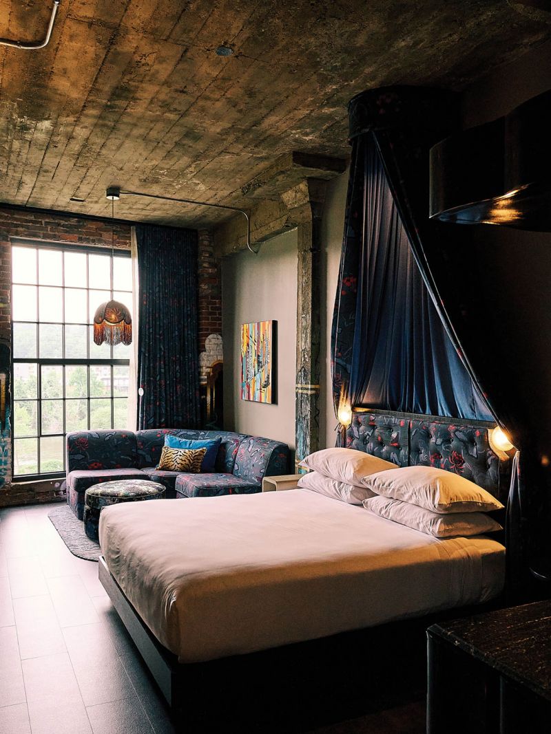 Tall windows and original artwork in a guest room at The Radical.