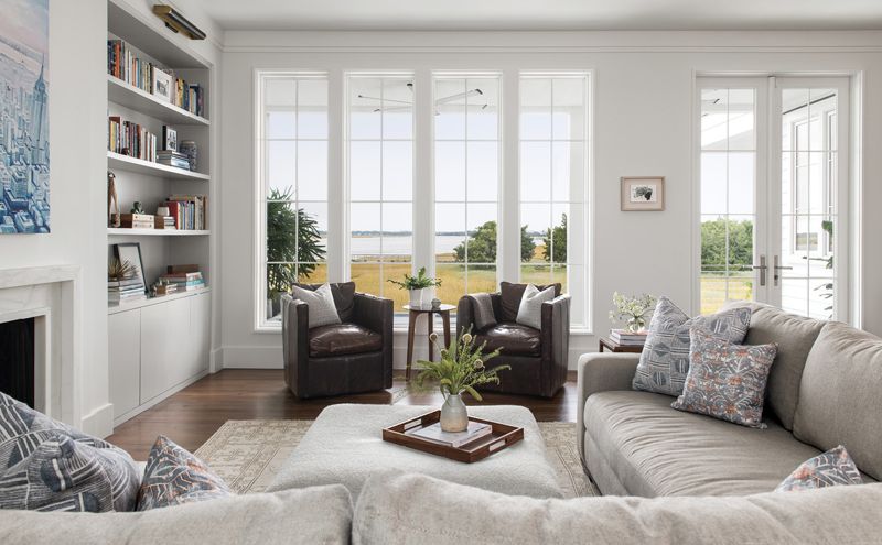 A Cisco Brothers ottoman covered with a Holly Hunt bouclé fabric sits on top of a vintage Khotan rug, and pillows covered in Mark Alexander and ZAK+FOX fabrics add a pop of pattern.