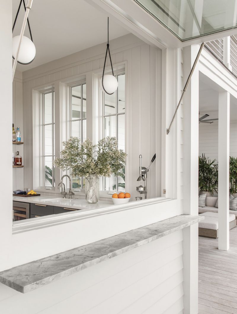 The doors to the left lead to an indoor/outdoor bar area, where a large window opens to the deck.