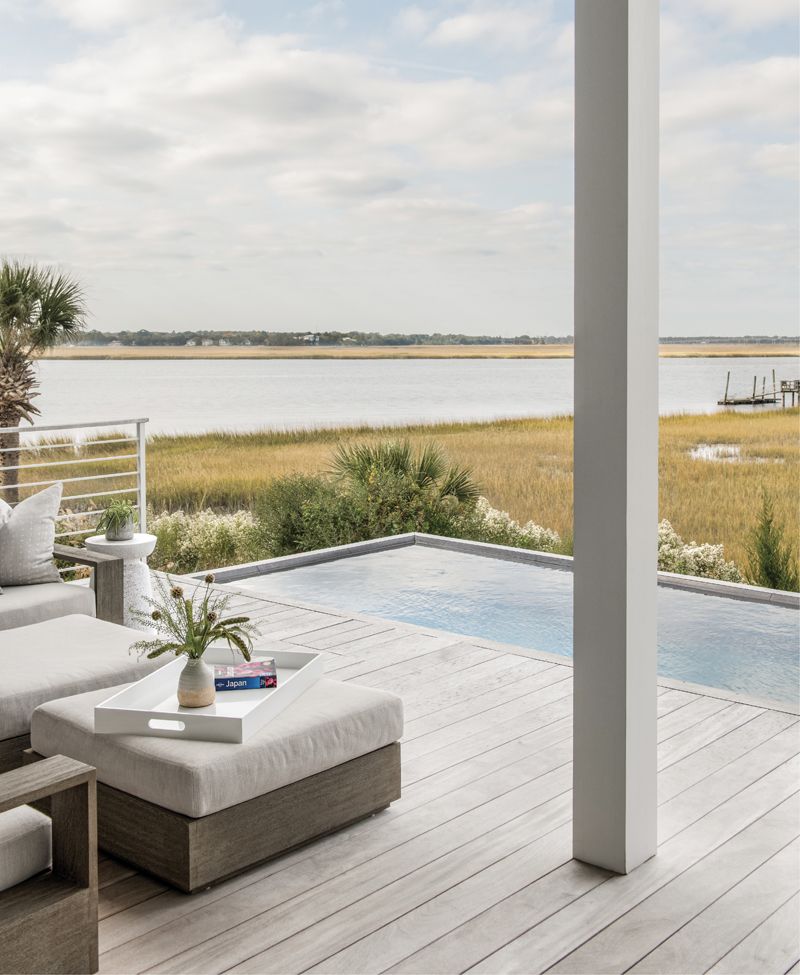 Outdoor Oasis: The main outdoor deck features a pool, installed by Aqua Blue, and an Ipe wood deck furnished with an outdoor sectional in a rugged Perennials fabric, accessorized with Clay McLaurin throw pillows. Melissa and Brad love to watch dolphins and their babies frolic in the river while soaking up the sunsets over the Ashley.